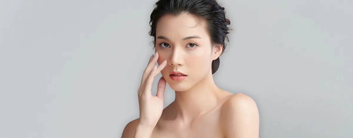 Woman touching her cheek – CO₂ laser resurfacing in Calgary