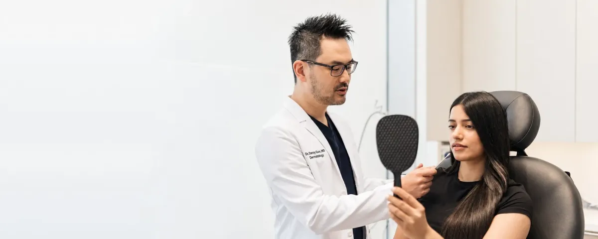 Dr. Danny Guo discussing dermal filler treatment with a patient in Calgary