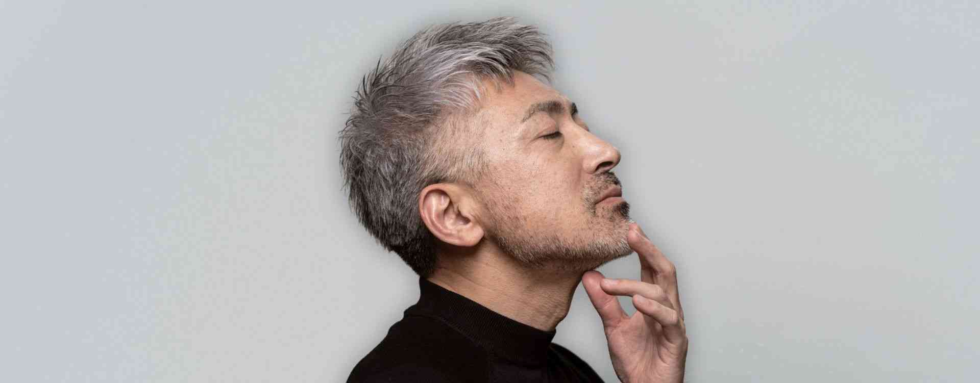 Mature man with grey hair touching his chin – laser skin resurfacing in Calgary