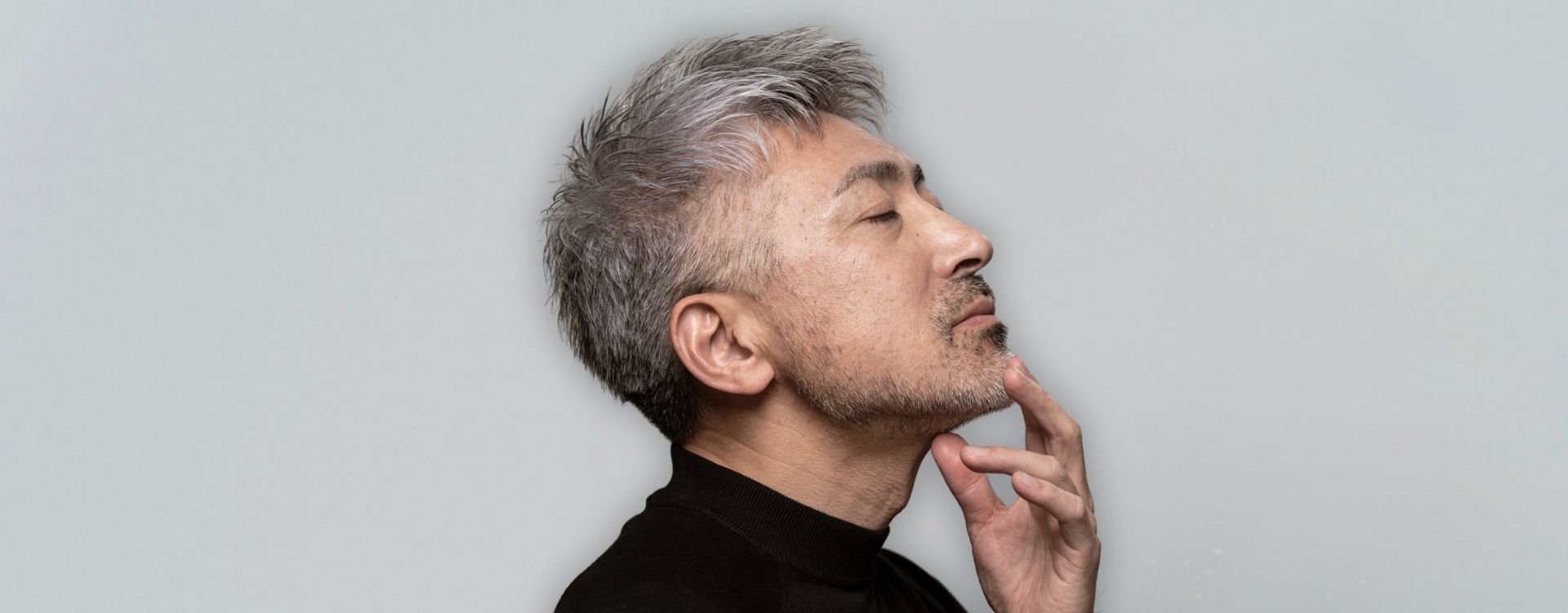 Mature man with grey hair touching his chin – laser skin resurfacing in Calgary