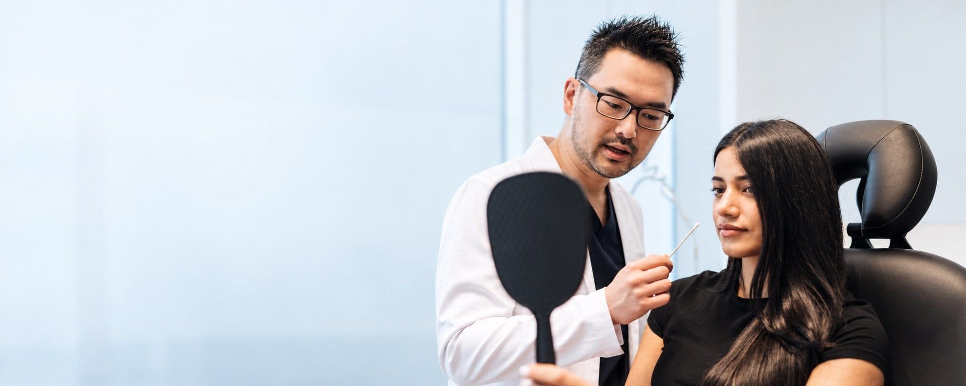 Dr. Danny Guo discussing dermal filler treatment with a patient in Calgary